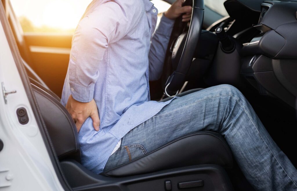 Driver experiencing delayed back pain after a car accident, illustrating why the discovery rule is vital for personal injury claims in Florida.