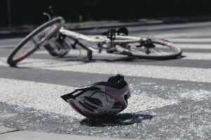 Cyclist helmet and broken glass on road after bicycle crash